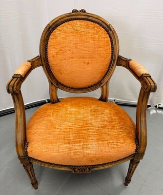 orange upholstered chair in a corner of a room with a white wall