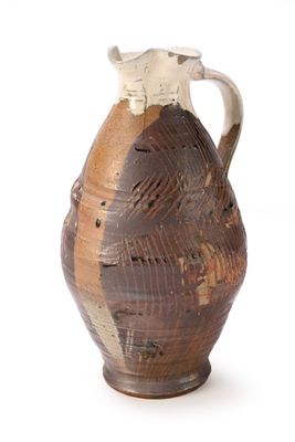 a brown and white vase with a handle on a white background