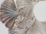a mirror that has a bunch of silver leaves on it