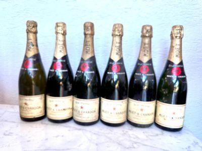 six bouteilles de champagne alignées sur une table