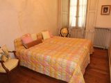 brightly colored bedspread on a bed in a bedroom with a chair and radiator