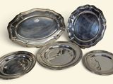 six plateaux plaqués argent sur un fond blanc avec un arrière-plan bleu
