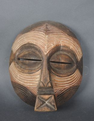 une image représentant un masque en bois sur lequel figure un visage