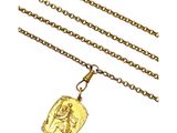 un gros plan d'un collier avec une pièce d'or suspendue à une chaîne