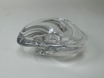 une sculpture en verre représentant une vague sur une surface blanche