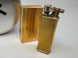 a gold lighter next to a silver ball