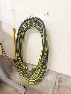 a yellow and black hose next to a white wall