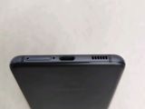 the back of a black cell phone sitting on top of a table