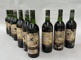 six bottles of wine are lined up in a row on a white surface