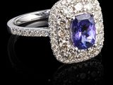 une bague ovale sertie d'une tanzanite et de diamants, posée sur un fond noir