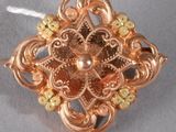 an image of a gold broochle on a white string