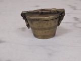 a small brass bowl sitting on a marble table