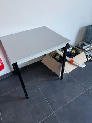 une petite table sur laquelle est posé un sac rouge