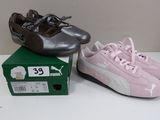 two pairs of puma shoes sitting on top of a box on a table