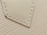a white bag with a tag on it on a bed