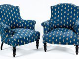 une paire de fauteuils rembourrés bleus ornés d'un motif à la feuille d'or