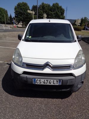 la camionnette blanche est garée sur un parking avec des arbres en arrière-plan