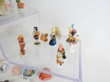 many small figurines displayed on a clear shelf