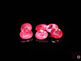 deux diamants roses en forme de cœur sur un fond noir