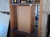 a shelf with bottles of alcohol on it next to a refrigerator