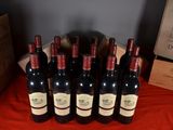 six bottles of red wine are lined up on a table