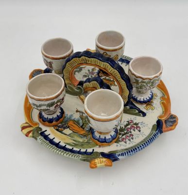 un plateau sur lequel sont posés des tasses et des soucoupes, posé sur une surface blanche