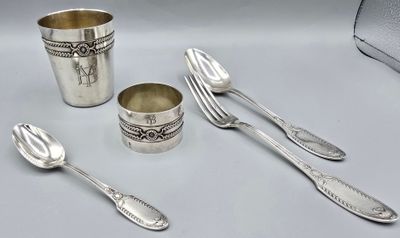 un service d'argenterie comprenant des cuillères, disposées sur une table