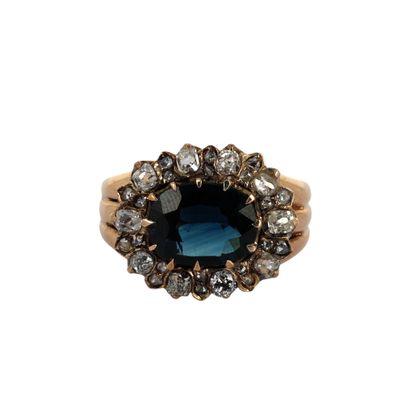 gros plan d'une bague avec une pierre bleue entourée de diamants