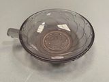 a glass bowl with a coin in it on a table