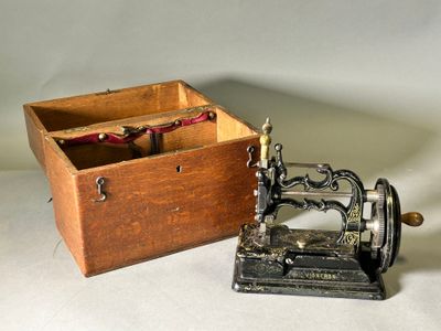 a small wooden box with a sewing machine inside of it