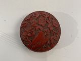un petit objet rouge posé sur une surface blanche, sur une table