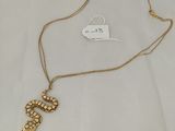 a close up of a necklace on a white cloth with a tag