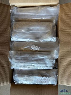 plusieurs paquets de nourriture sont posés dans un carton posé par terre
