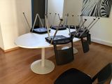 a white table with four chairs and a zebra painting on the wall