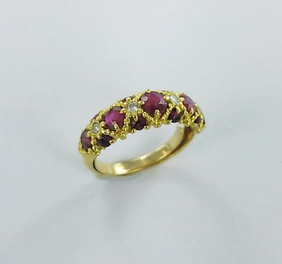 a close up of a gold ring with rubis and diamonds