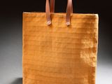 an orange tote bag sitting on top of a white table