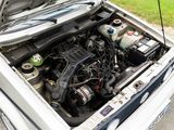 a white car with its hood open and the engine in the trunk