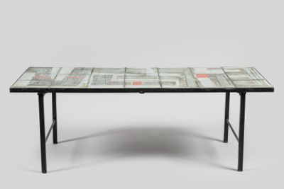 La table est fabriquée à partir de pages de journaux et possède un piètement en métal noir.
