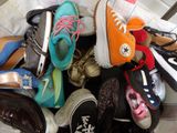 many pairs of shoes that are piled together on a bed
