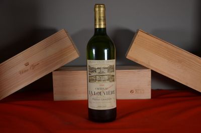 a bottle of wine sitting on a table next to two wooden boxes