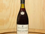une bouteille de vin posée sur un tonneau en bois