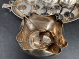 a silver plate with a spoon in it on a table