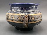 an image of a blue and gold vase on a table