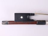 a violin bow and a bow rest on a white surface