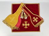 a red and yellow table cloth with gold decorations on it