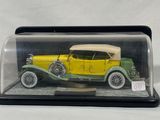 a model of a yellow car in a glass case