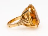 an image of a yellow gold ring with a large faceted citrine stone
