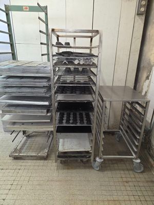 many trays of food on a metal rack in a kitchen