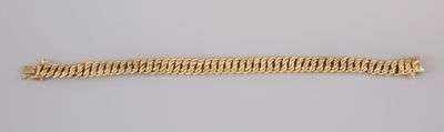 a close up of a gold bracelet on a white surface