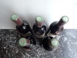 several bottles of wine are lined up on a counter top